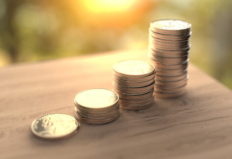 Stack of coins on table Stack of quarters on table with early morning light