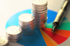 Stack of coins on asset allocation chart Paper with asset allocation pie chart, stacks of coins, and ballpoint pen