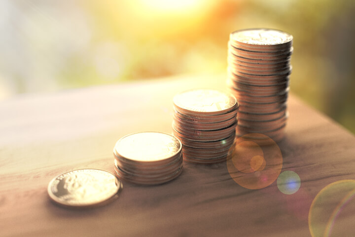Stacks of coins concept for investment income in morning light with lens flare effect