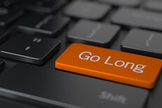Go Long keyboard key Dark computer keyboard with large orange Go Long key concept for investment strategy