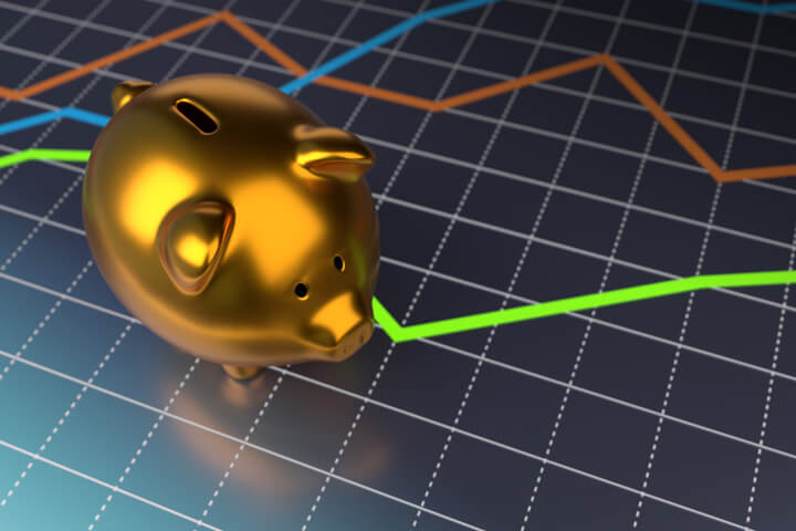 Shiny metallic gold piggy bank on top of glossy line chart with reflection