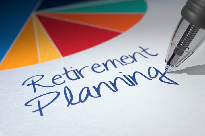 Paper with colorful pie chart and Retirement Planning written by ballpoint pen