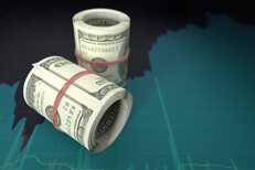 Money rolls on stock price chart Two rolls of U.S. currency on screenshot of stock price area chart