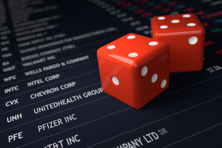 Two red dice on top of stock exchange listings concept for investment risk