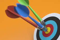 Colorful darts hit target Three darts all hit the bulls eye of a target on white background