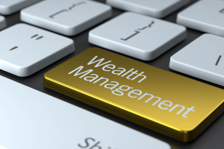 Computer keyboard with shiny gold Wealth Management key concept for financial planners or weath managers