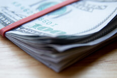 Corner view folded bills Corner view of folded $100 bills with rubber band