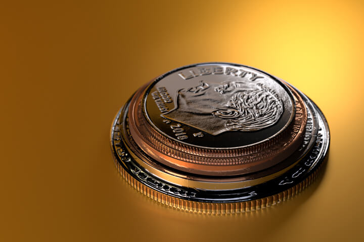U.S. coins stacked on gold background with strong spotlight