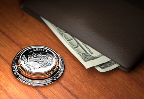 Coins wallet and bills U.S. coins stacked on wood table with wallet with protruding bills harder spotlight