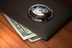 Coins on wallet U.S. coins stacked on top of leather wallet with protruding one hundred dollar bills