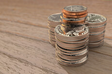 Large stacks of coins Three large stacks of shiny quarters with other smaller coins on top