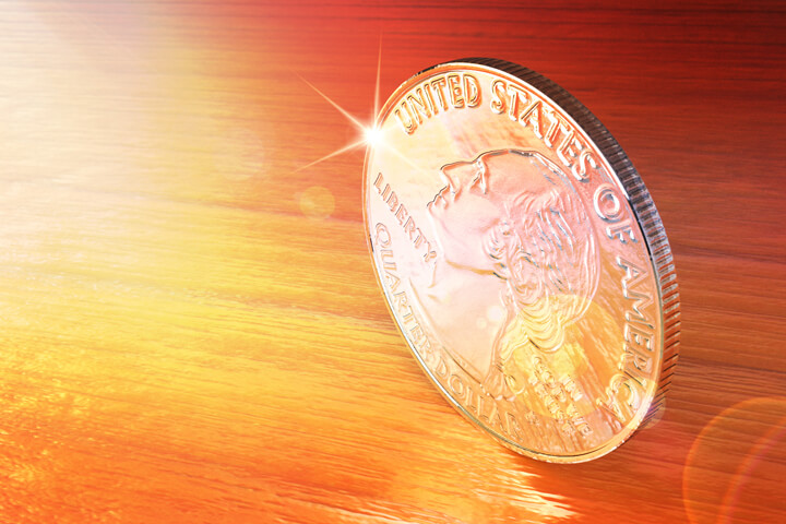 U.S. quarter coin on edge on wood table with lens flare and overlay effect