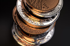 Closer top view of large stack of U.S. coins on black background