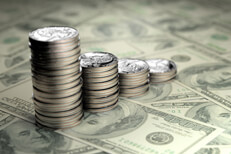 U.S. quarters stacked from large to small on top of one hundred dollar bills