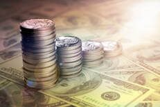 Quarter stacks reversed with effect U.S. quarters stacked from large to small on top of one hundred dollar bills with lens flare and overlay