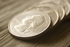 Row of quarter coins on wood Row of quarter coins laid on wood background