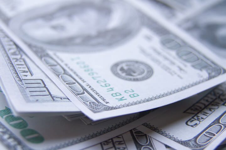 Sloppy stack of $100 bills with depth of field blur
