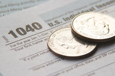 Tax form with quarters Two shiny U.S. quarters on IRS tax form 1040 concept for tax budget or paying income taxes