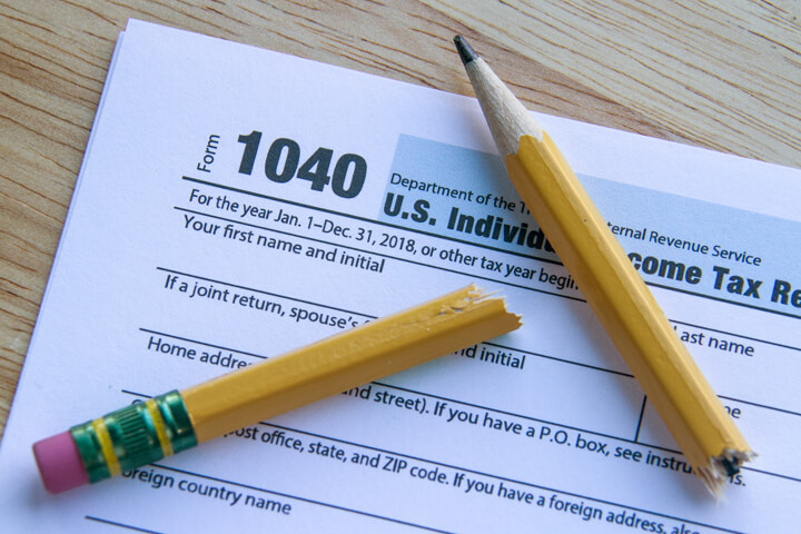IRS form 1040 on desk with broken pencil top view concept for irritation or frustration