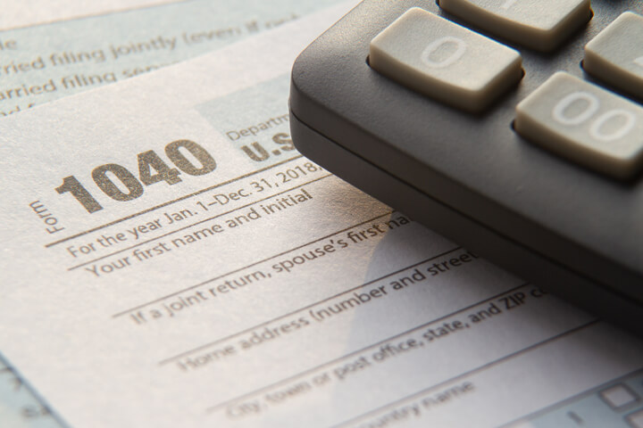 Close up photo of IRS 1040 tax form with calculator