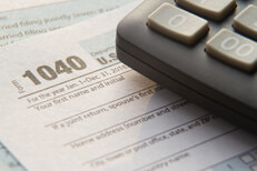 Close view of tax 1040 form with calculator Close up photo of IRS 1040 tax form with calculator