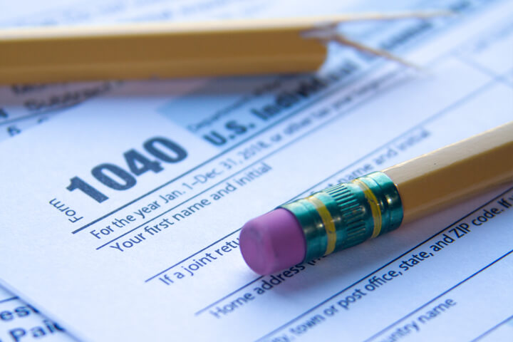 Sunlight photo of IRS form 1040 with broken pencil concept for tax time frustrations