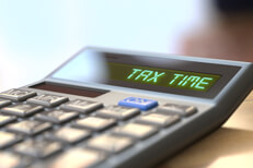 Calculator reading Tax Time Tax concept image of a calculator with LCD reading Tax Time