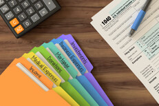 Desk with tax prep items Desktop overhead view showing calculator, tax folders, and IRS form 1040