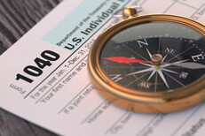 Form 1040 tax help IRS form 1040 on wood background with navigation compass concept for tax help, direction, or advice