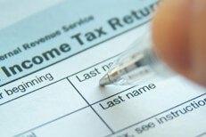 Income tax return photo Photo of pen filling out 1040 form with focus on Income Tax Return text