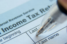 Filling out 1040 tax form Close up photo of ball point pen in Last Name field of IRS form 1040
