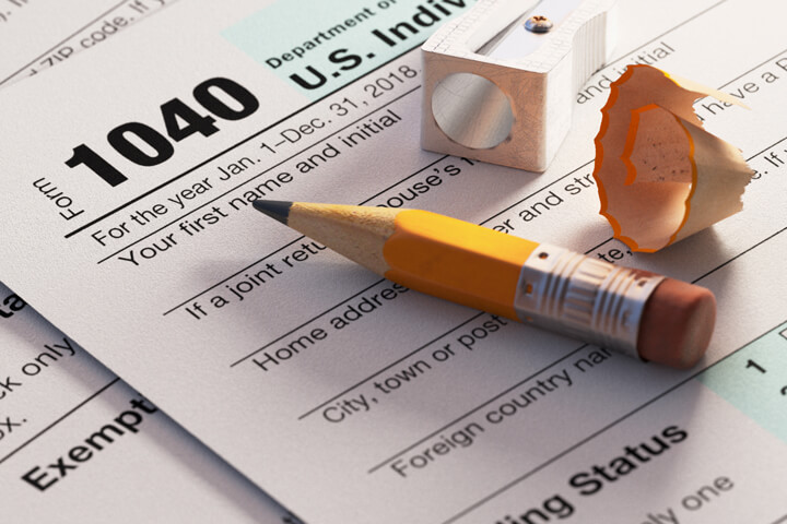 1040 tax form with short stubby pencil, sharpener, and shaving