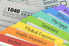 Colorful tax folders with 1040 Rainbow manila tax category folders lying on IRS form 1040