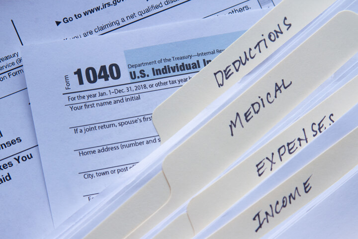 Manila folders for income, expenses, medical, and deductions on 1040 IRS form