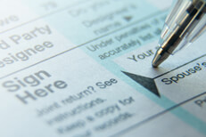 Signing tax form Close up photo of pen signature on IRS 1040 tax form with highlight