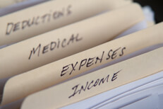 Manila folders for taxes Manila filing folders with tax income, expenses, medical, and deductions and camera depth of field
