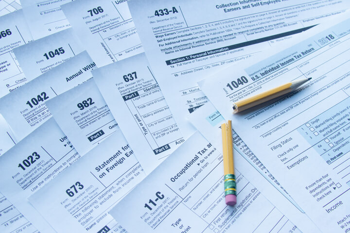 Broken pencil lying on many IRS tax forms concept for tax filing frustration or confusion