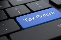 Laptop keyboard with tax return key Dark laptop keyboard with blue tax return key concept photo for electronic tax filing