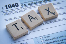 Tax Scrabble letters Wooden Scrabble letters spelling TAX on IRS form 1040