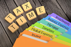 Tax time folders Fanned rainbow-colored manila folders for tax categories with Scrabble letters spelling TAX TIME