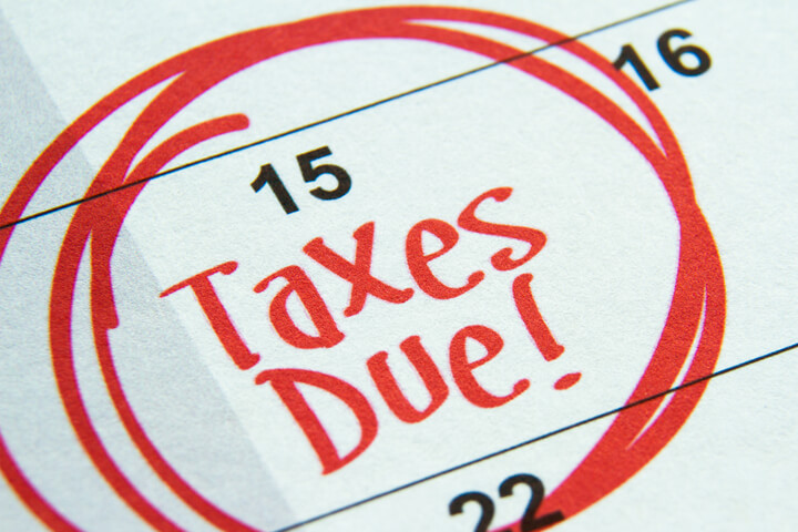 Calendar showing April 15th circled in red marker with Taxes Due text concept for tax deadline