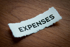 Expenses on torn paper Torn piece of paper with word Expenses with depth of field blur and woodgrain background
